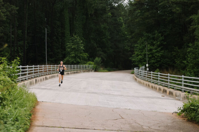 Runner running across bridge from Umstead State Park