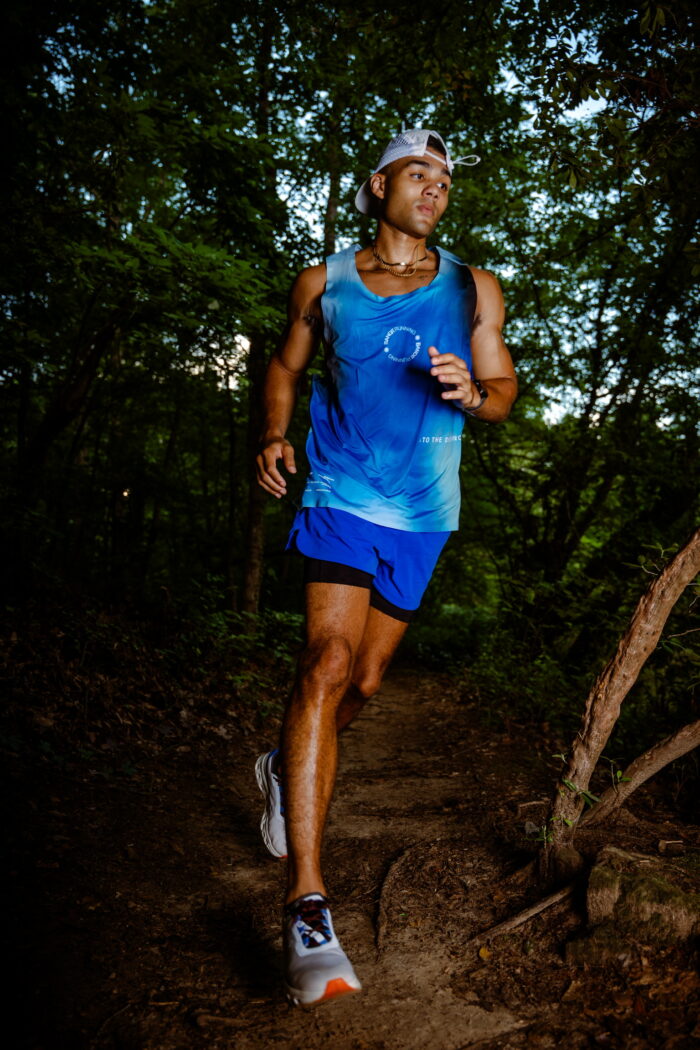 Model running through the woods with a bandit running outfit on.