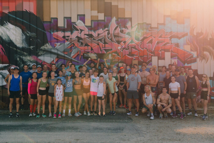 A crowd of people posing for a picture with some elite runners