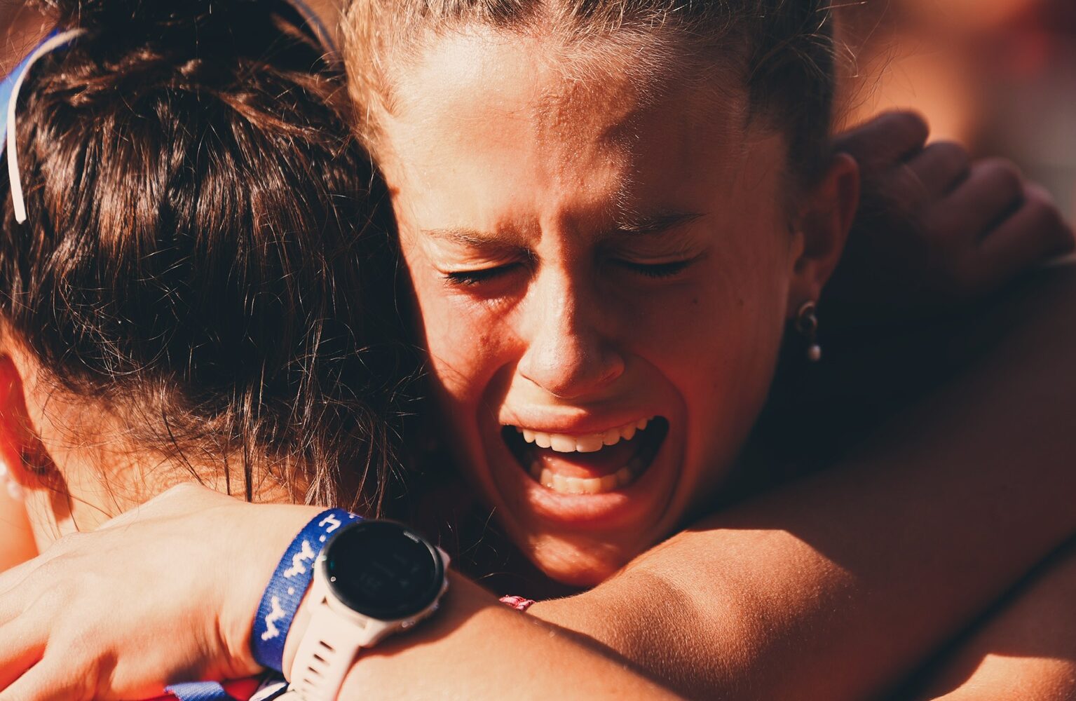 Two girls embracing post race